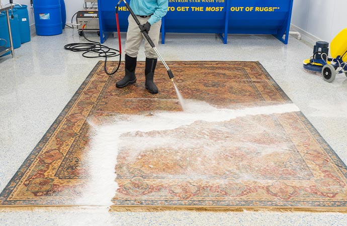 worker maintaining a rug with cleaning tools.
