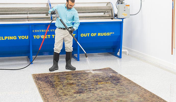 Rug cleaning using pressure-washing