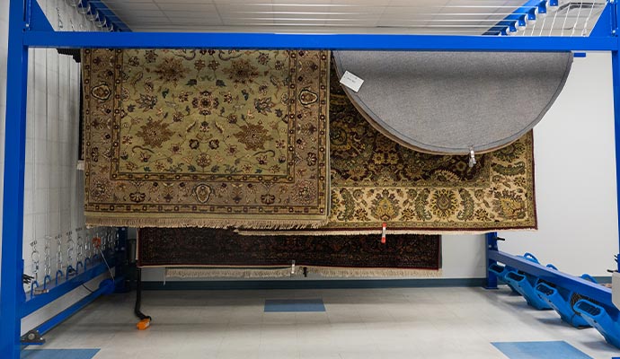 Rugs hanging on industrial rug drying rack Rugs hanging on industrial rug drying rack