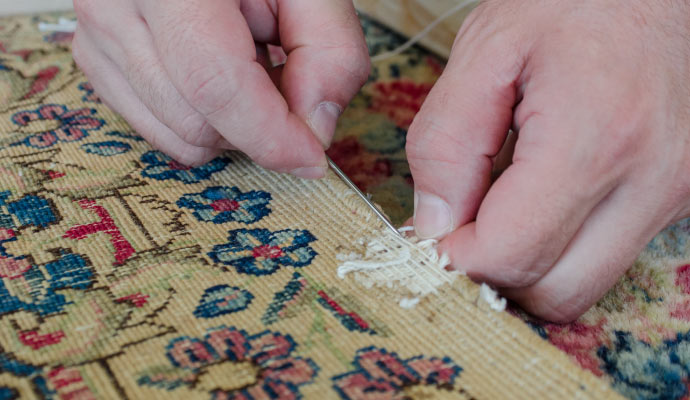 a professional repairing a rug